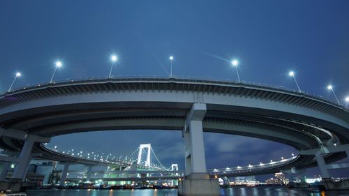 Low angle view of illuminated bridge against blue sky