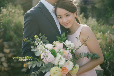 Portrait of woman with pink flowers against plants