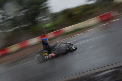 Blurred motion of person riding motorcycle on road