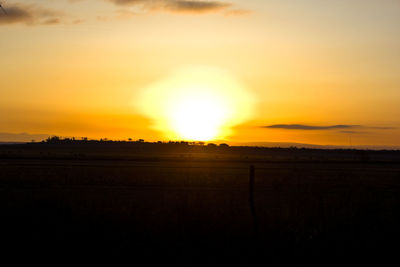 Scenic view of silhouette field against sky during sunset