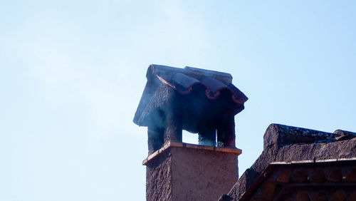 Low angle view of old building roof against clear sky