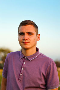 Portrait of young man standing against clear sky