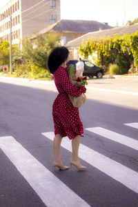 Rear view of woman walking on road