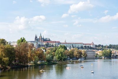 Scenic view of river by buildings against sky