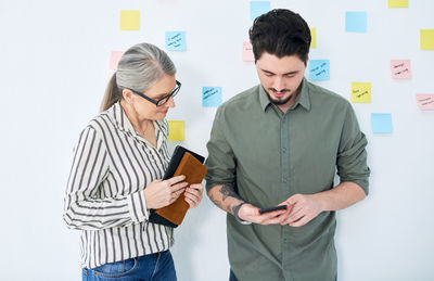 Business colleagues using mobile phone