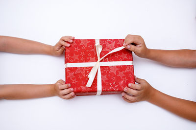 Midsection of child holding paper against white background