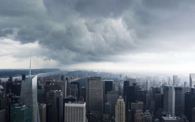 Bank of america tower and modern buildings against cloudy sky