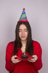 Portrait of beautiful young woman against red background