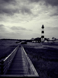 Lighthouse on field against sky