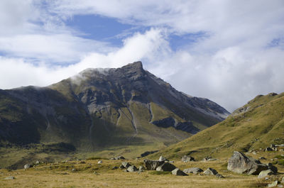 Scenic view of landscape and mountains against cloudy sky