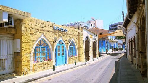 View of buildings against clear blue sky