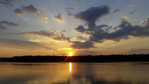 Reflection of clouds in calm lake at sunset