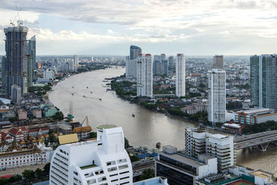 High angle view of river amidst buildings against sky