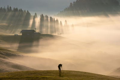 Man on field against sky during sunset