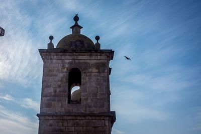 Low angle view of building against cloudy sky