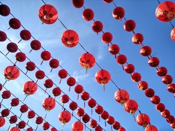 Low angle view of lanterns hanging against sky