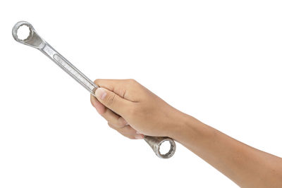 Close-up of hand holding metal against white background