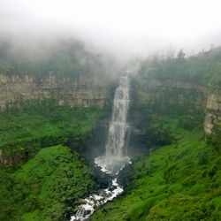 Scenic view of waterfall against sky