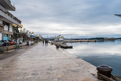 Pier amidst buildings in city against sky