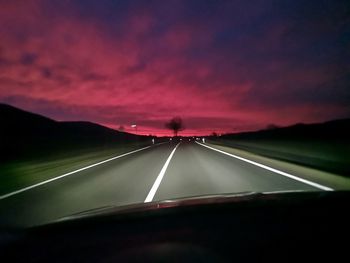 Car on road against sky at sunset