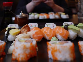 Close-up of sushi against person sitting at table