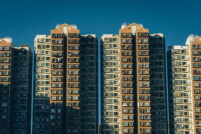 Low angle view of buildings against clear blue sky