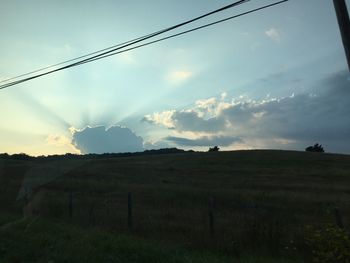 Scenic view of field against cloudy sky