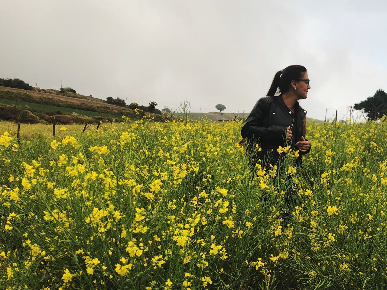 yellow, one person, field, land, real people, beauty in nature, flower, plant, sky, flowering plant, growth, young women, lifestyles, standing, young adult, nature, three quarter length, leisure activity, oilseed rape, casual clothing, farm, outdoors