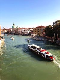 High angle view of boats in canal against buildings and sky