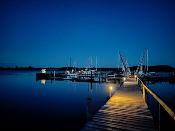 Pier over lake against blue sky