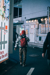 Rear view of people walking on street in city
