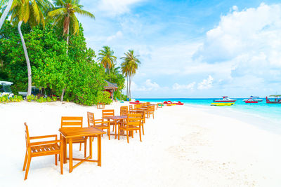 Chairs on beach against sky