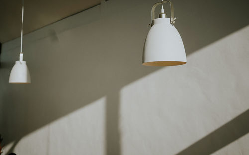 Low angle view of pendant light hanging on wall at home