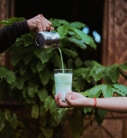 Midsection of person pouring drink in glass