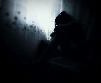 Side view of silhouette man sitting at home