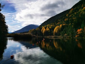Scenic view of lake by mountains against sky