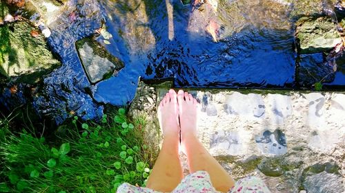 Low section of woman standing in water