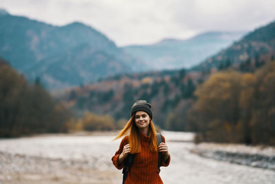 Portrait of young woman standing on mountain