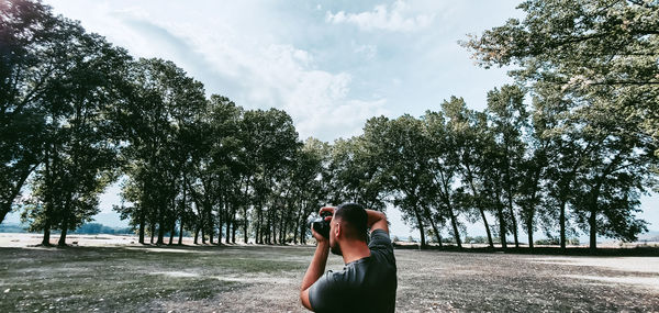 Woman photographing against sky