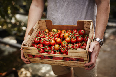 Man holding box with cherry tomatoes