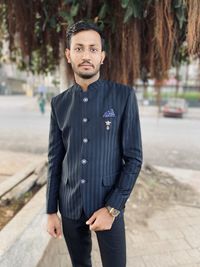 Portrait of young man standing in city