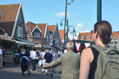 Rear view of people walking on street in city