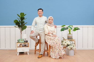 Portrait of smiling young couple sitting outdoors