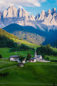 Houses on field by mountains against sky