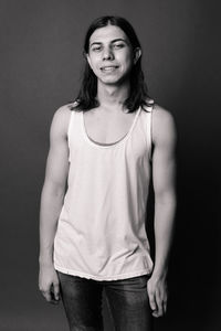 Portrait of man standing against black background