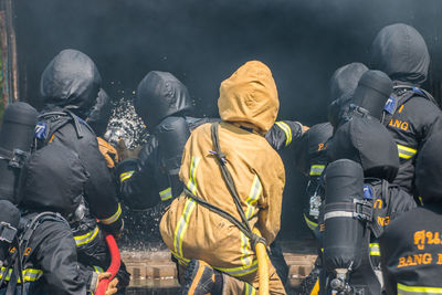 Rear view of firefighters extinguishing fire