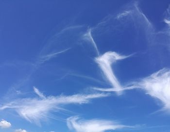 Low angle view of vapor trail in blue sky