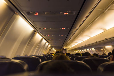 Passengers sitting in illuminated airplane