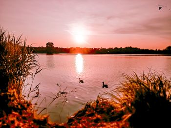 Scenic view of lake against sky during sunset