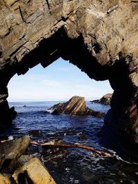 Scenic view of sea seen through cave